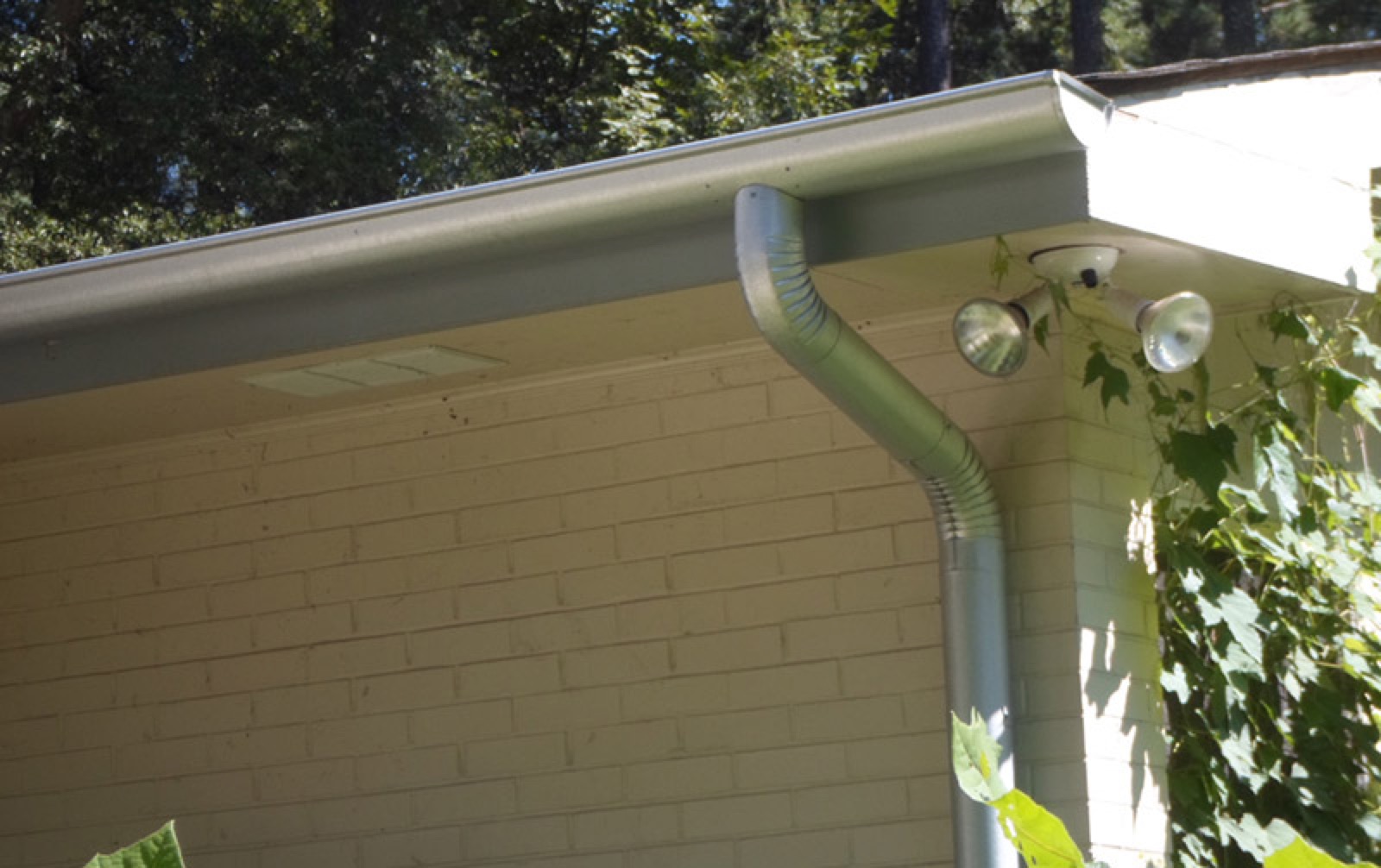 City Seamless half-round rain gutter with downspout routing on a custom home.