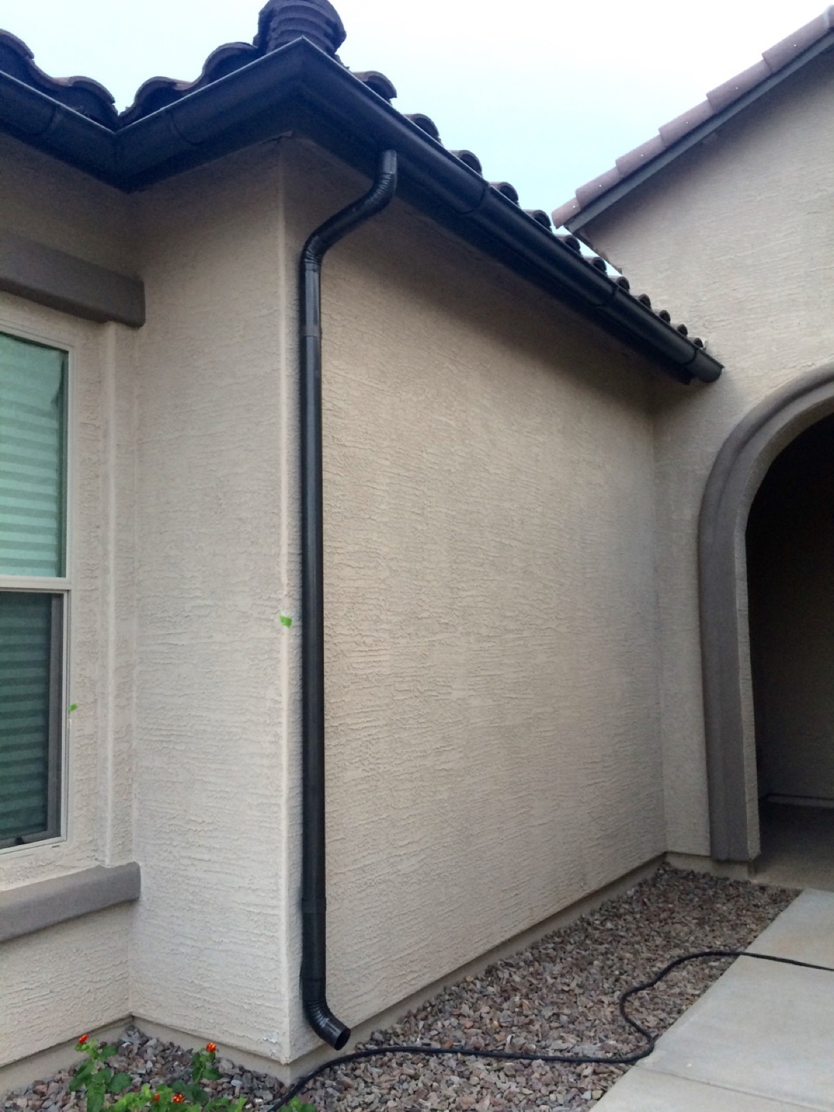 City Seamless half-round rain gutter with downspout routing on a custom home.