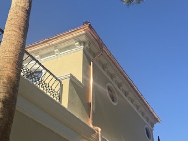 City Seamless half-round rain gutter with downspout routing on a custom home.
