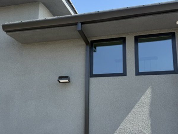 City Seamless straight-face gutter with downspout routing on a modern roofline.