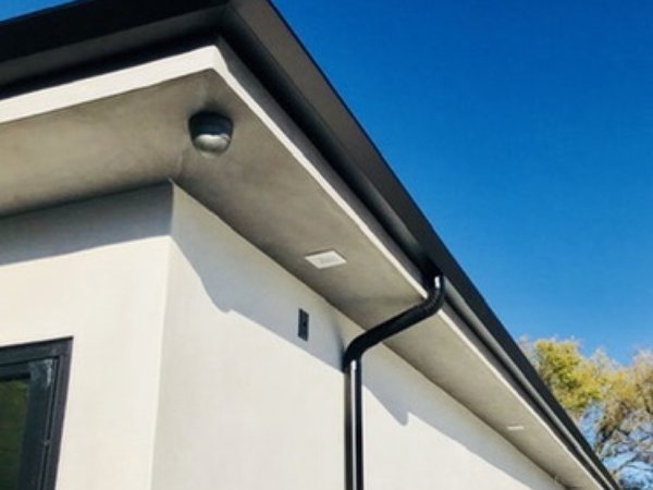 City Seamless straight-face gutter with downspout routing on a modern roofline.
